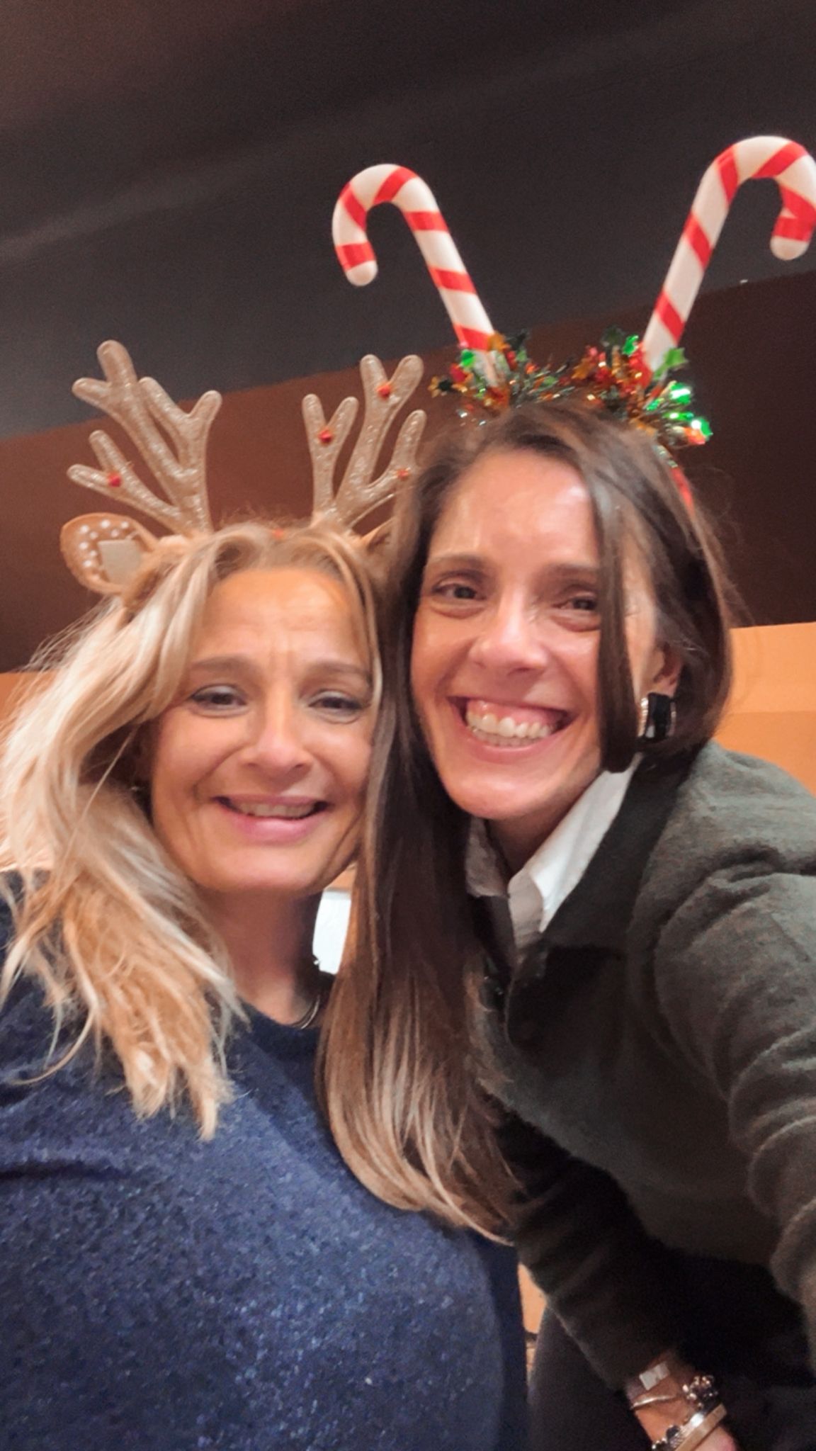Jantar de Natal 2025 — duas membros com headbands de rena e bengala